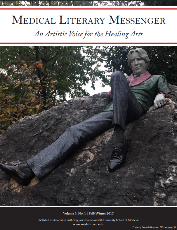 Photo of a statue of a man on a rock, with trees visible in the background, the MLM banner is over the top of the photo